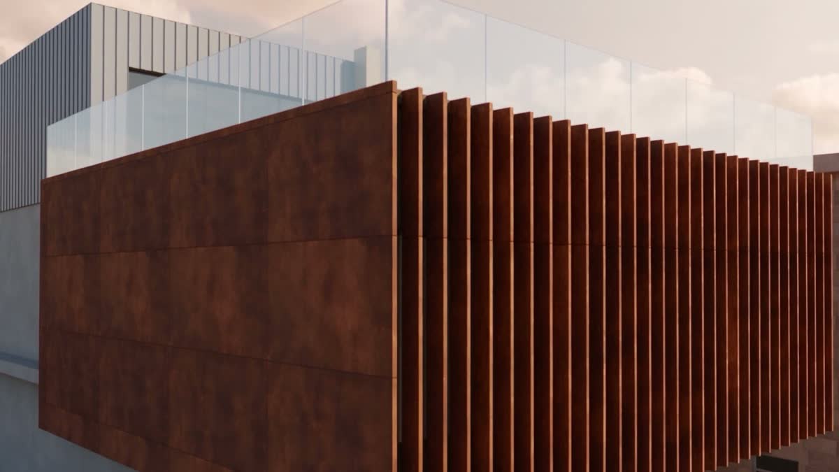 Close view of the corten cladding and its vertical fins, with glass balustrades on the roof above.